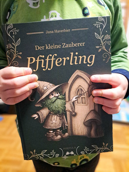 Ein Kind hält das Kinderbuch Der kleine Zauberer Pfifferling in den Händen.